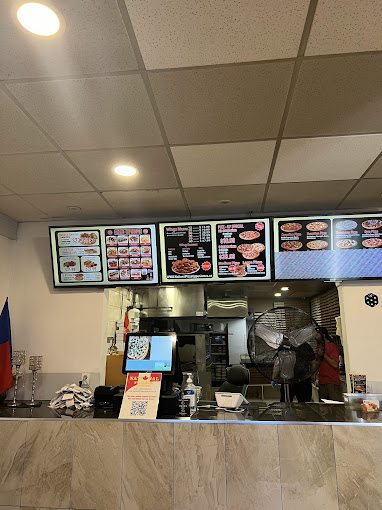 Inside National Pizza & Wings, menu boards above the counter